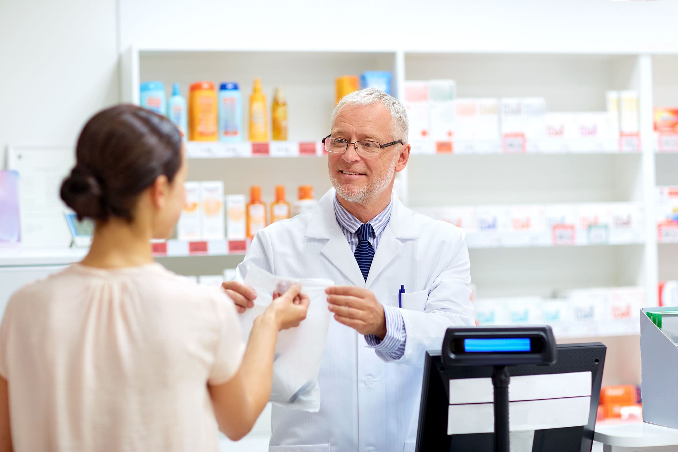 Pharmacist at counter assisting a customer